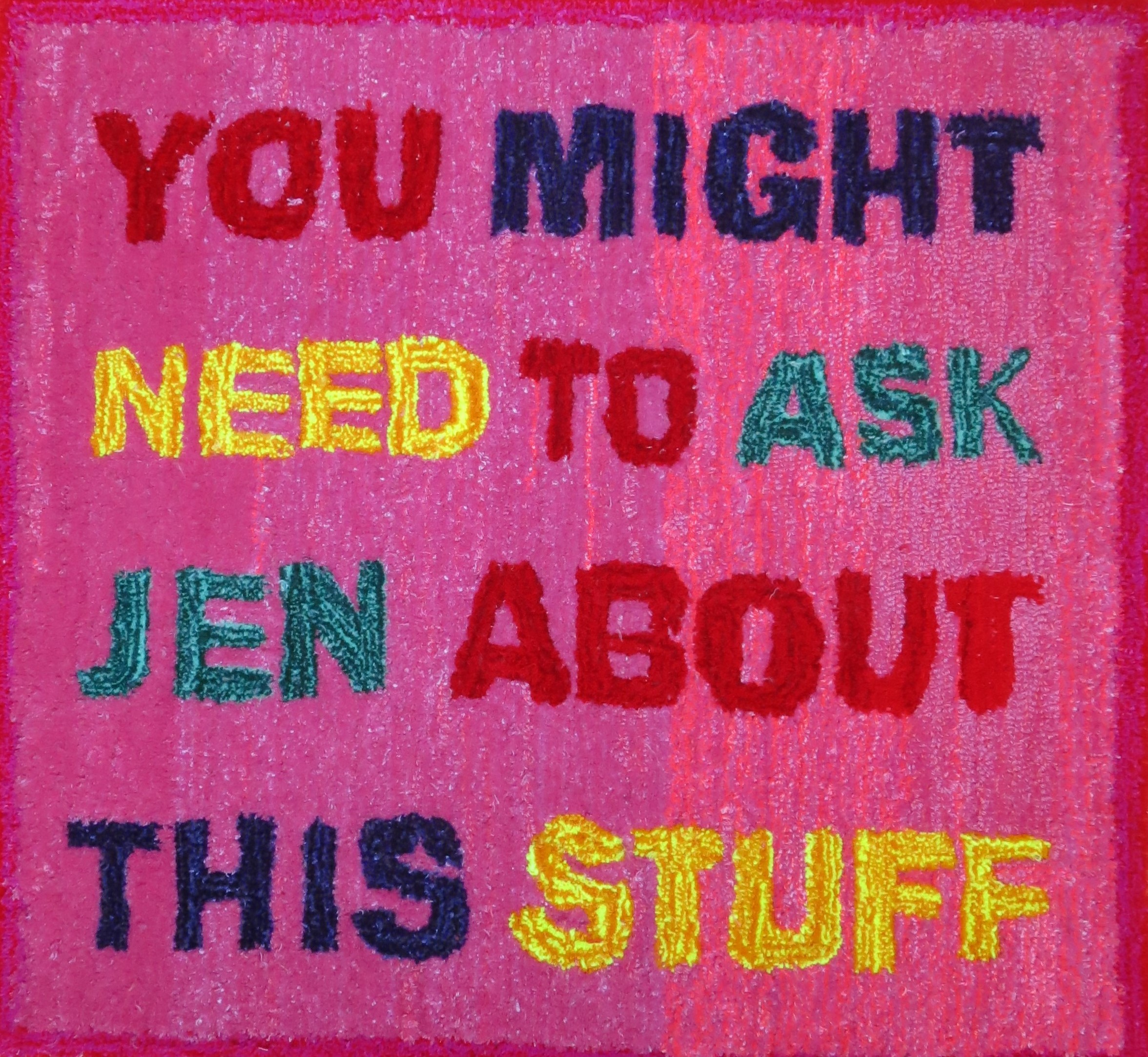 The image shows a vibrant pink background with text that appears to be either embroidered or woven on a shaggy rug surface. At the top, the text reads "YOU MIGHT", followed by "NEED TO ASK" in the middle. Below that is "JEN ABOUT". Finally, at the bottom, there is more text that says, "THIS STUFF". The text is in various colours including yellow, dark blue, red, and aqua. This is a quote referencing the former Prime Minster of Australia. 
