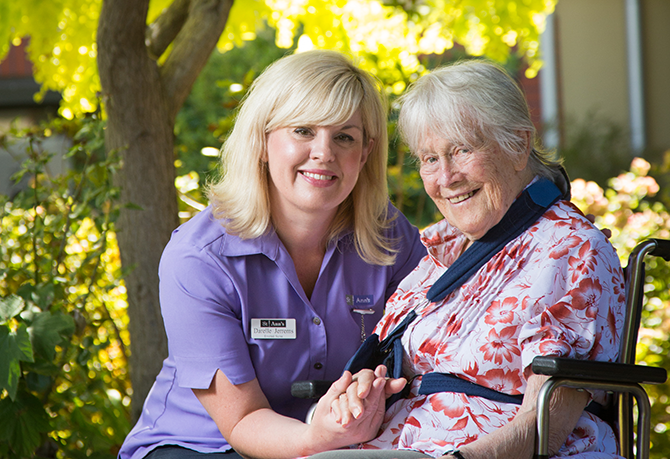 A nurse and an ederly woman sitting outdoors